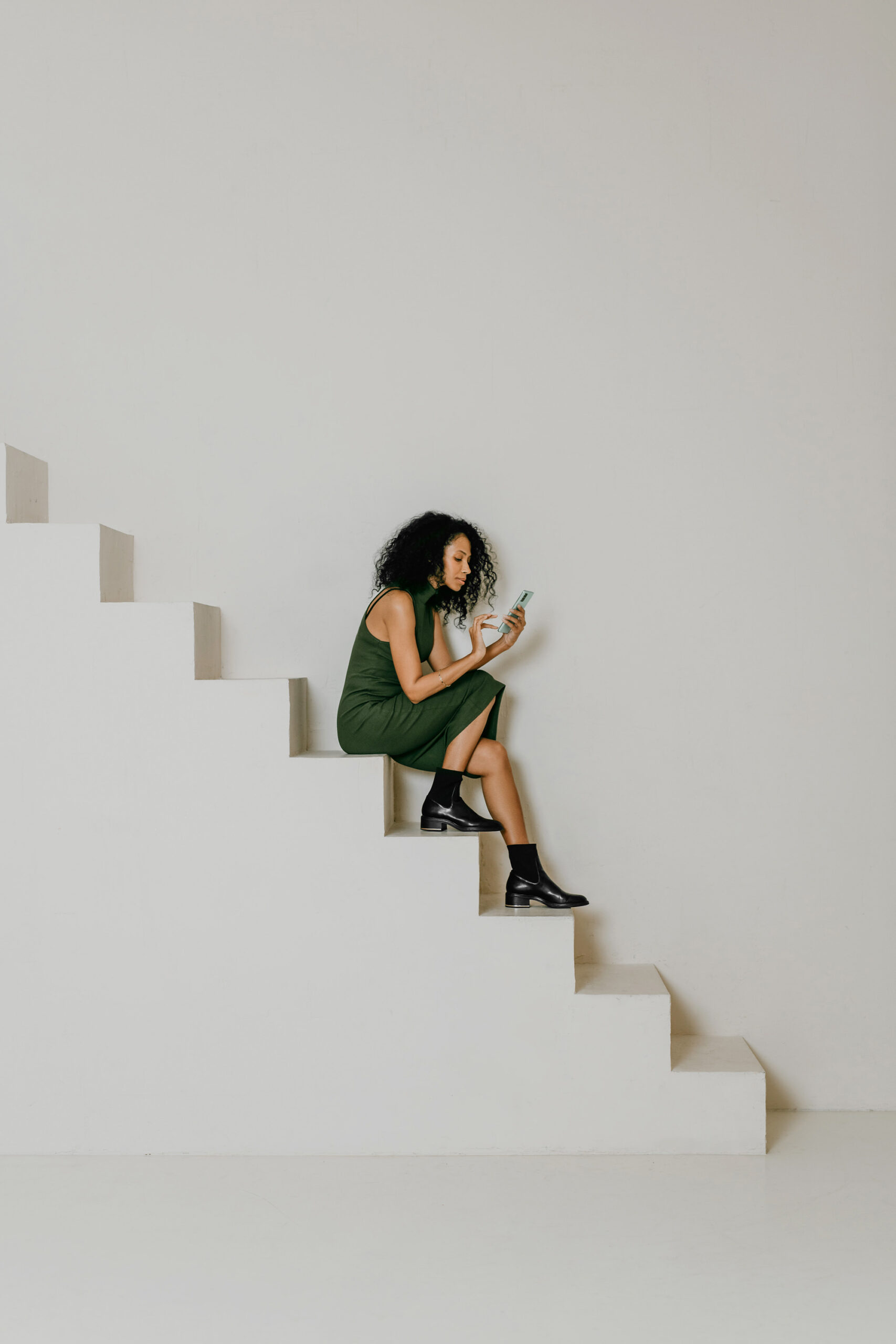 Person sitting on the stairs looking at mobile phone